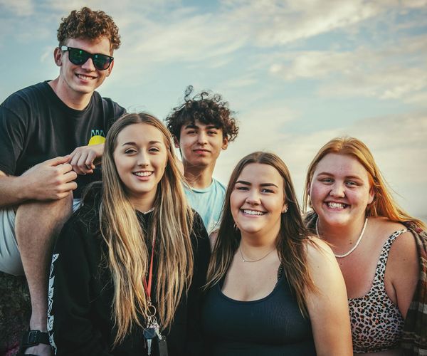 Diverse group of people smiling together in a welcoming environment.